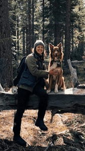 Image of Woman in Extreme Cruiser Vest Sitting on Log With A Dog