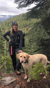 Image of Woman In Extreme Cruiser Vest On A Hill With A Dog