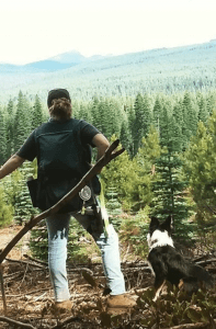 Image of Woman in Forest Wearing An Extreme Cruiser Vest Looking at The Trees With Dog